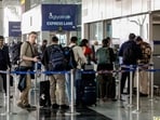 Passengers stand in a queue at the Indigo check-in counter with their luggage after IndiGo cancelled flights at the Indira Gandhi International Airport, in New Delhi 