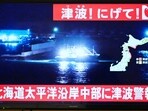 TOPSHOT - An advisory reading "Tsunami! Run!" (top) and "Tsunami warning issued for central Hokkaido�s Pacific Coast" flashes over the live footage of a boat leaving a port, on a television screen in Sapporo, in Japan�s northern Hokkaido prefecture on December 8, 2025. Japan recorded a 40-centimetre (16-inch) tsunami after a 7.6-magnitude quake on December 8. (Photo by GREG BAKER / AFP) TOPSHOT - An advisory reading "Tsunami! Run!" (top) and "Tsunami warning issued for central Hokkaido�s Pacific Coast" flashes over the live footage of a boat leaving a port, on a television screen in Sapporo, in Japan�s northern Hokkaido prefecture on December 8, 2025. Japan recorded a 40-centimetre (16-inch) tsunami after a 7.6-magnitude quake on December 8. (Photo by GREG BAKER / AFP)