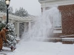 A person cleans up snow from the sidewalk at The University of Virginia as a winter storm sweeps through Charlottesville, Va., dropping three inches of snow early in the morning on Friday, Dec. 5, 2025. (Cal Cary /The Daily Progress via AP)