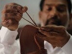 A craftsman works on limited-edition Prada leather sandals inspired by India's traditional Kolhapuri footwear