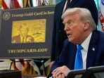 A poster showing the Trump Gold Card is seen as President Donald Trump signs executive orders in the Oval Office of the White House.