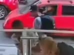 The video captures a man approaching the woman and attempting to cut the straps of her backpack. The video captures a man approaching the woman and attempting to cut the straps of her backpack.