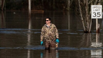 Drew Glastetter walks through floodwaters in an area flooded by the Snoqualmie River, as an atmospheric river brings rain and flooding to the Pacific Northwest, in Fall City, Washington, U.S., December 9, 2025.  REUTERS/David Ryder (REUTERS)