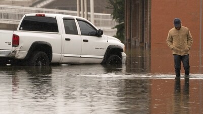 A person walks through floodwater, as an atmospheric river brings rain and flooding to the Pacific Northwest, in Sultan, Washington, U.S., December 10, 2025.  REUTERS/David Ryder (REUTERS)