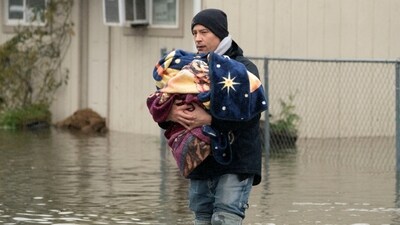 Brandon Phasith carries belongings while evacuating amidst rising floodwater, as an atmospheric river brings rain and flooding to the Pacific Northwest, in Sultan, Washington, U.S., December 10, 2025.  REUTERS/David Ryder (REUTERS)