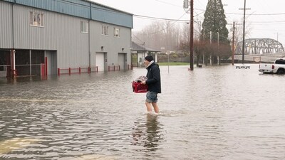 Another photo of Brandon Phasith carriying belongings while evacuating amidst rising floodwater (REUTERS/David Ryder) (REUTERS)