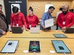 Staff members, assisting customers during the launch of Apple's new store, in Noida on Thursday.