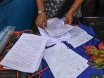 Election Commission officials assist voters at a help desk camp for the Special Intensive Revision (SIR) of electoral rolls. Election Commission officials assist voters at a help desk camp for the Special Intensive Revision (SIR) of electoral rolls.