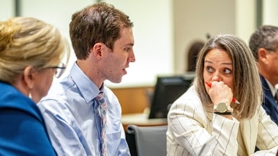 Defense attorneys Kathryn Nester, left, and Staci Visser, right, speak with Tyler Robinson, who is accused of fatally shooting Charlie Kirk, during a hearing, Thursday, Dec. 11, 2025, in Fourth District Court in Provo, Utah (AP)