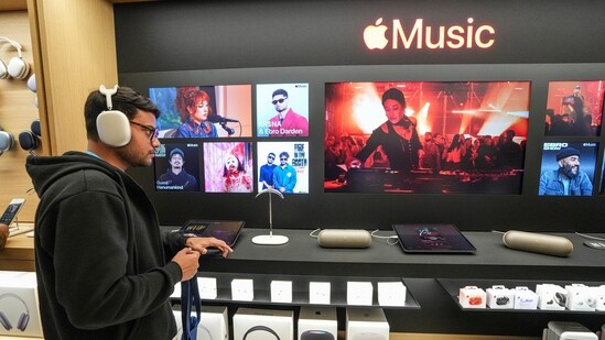 A customer checks an Apple headphone during the launch of the company's new store in Noida.(PTI)