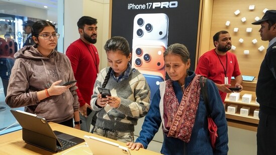 Customers checking Apple products during the launch of the company's new store in Noida.(PTI)