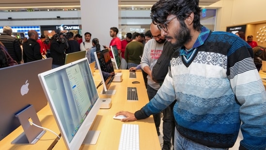Customers check iMac, all-in-one desktops, being displayed during the launch of Apple's new store in Noida.(PTI)