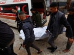 Palestinians and Emergency personnel carry a white body bag of a victim at Al-Shifa Hospital targeted by an Israeli strike on a car in Gaza City, on December 13, 2025. (Photo by Omar AL-QATTAA / AFP) Palestinians and Emergency personnel carry a white body bag of a victim at Al-Shifa Hospital targeted by an Israeli strike on a car in Gaza City, on December 13, 2025. (Photo by Omar AL-QATTAA / AFP)