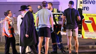 Health workers put a patient into an ambulance after a shooting incident at Bondi Beach in Sydney on December 14, 2025. Australian police said two people were taken into custody following reports of multiple gunshots on December 14 at Sydney's famed Bondi Beach, urging the public to take shelter. (Photo by Saeed KHAN / AFP) (AFP) Health workers put a patient into an ambulance after a shooting incident at Bondi Beach in Sydney on December 14, 2025. Australian police said two people were taken into custody following reports of multiple gunshots on December 14 at Sydney's famed Bondi Beach, urging the public to take shelter. (Photo by Saeed KHAN / AFP) (AFP)
