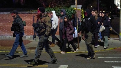 Law enforcement officers escort students near the Barus & Holley engineering building at Brown University campus in Providence, Rhode Island, on December 13, 2025. (Photo by Bing Guan / AFP) (AFP) Law enforcement officers escort students near the Barus & Holley engineering building at Brown University campus in Providence, Rhode Island, on December 13, 2025. (Photo by Bing Guan / AFP) (AFP)