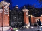 Visitors pause at a makeshift memorial for the victims at the Van Wickle Gate at Brown University, Monday, Dec. 15, 2025, in Providence, (AP Photo/Robert F. Bukaty)