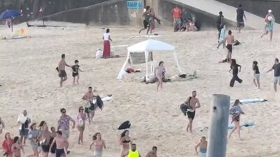 People run on the beach during a shooting incident on a Jewish holiday celebration at Bondi Beach in Sydney on Sunday. (Reuters)