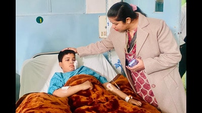 Mayor Inderjit Kaur with the injured child at the CMC hospital in Ludhiana on Monday. (HT Photo)