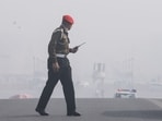 A security personnel walks across Vijay Chowk amid dense smog as Delhi’s AQI remains fell in the ‘very poor’ category, in New Delhi.