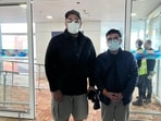 The photograph shows Gaurav and Saurabh Luthra standing side by side inside the Delhi airport terminal