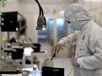 An employee works with a wafer on a production line of Dutch semiconductor company Nexperia in Hamburg, Germany. (REUTERS)