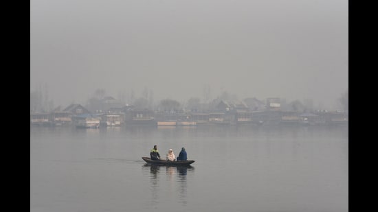 Srinagar, Dec 17 (ANI): Tourists enjoy Shikara ride in Dal Lake on a cold and foggy morning, in Srinagar on Wednesday. (ANI Photo) (Basit Zargar)