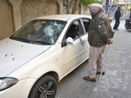 A policeman inspects the vandalised car vehicles outside the court complex in Ludhiana on Wednesday. (Gurpreet Singh/HT)