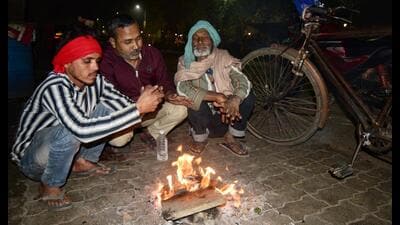 People sit around bonfires arranged by themselves in Lucknow on Thursday night. (HT Photo) People sit around bonfires arranged by themselves in Lucknow on Thursday night. (HT Photo)