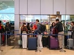 Passengers standing in a queue outside the Delhi airport.