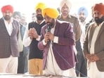 Chief minister Bhagwant Mann interacting with Satauj village residents in Sangrur on Friday. (HT)
