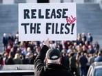 A protester holds a sign related to the release of the Jeffrey Epstein case files outside the US Capitol in Washington, DC.