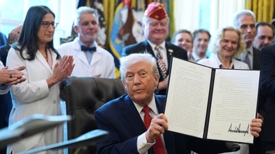 President Donald Trump displays an executive order (AP) President Donald Trump displays an executive order (AP)