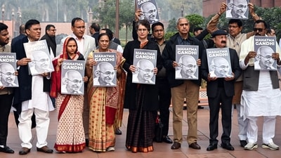 Congress MP Priyanka Gandhi Vadra with Sanjana Jatav and other MPs stand with banners with pictures of Mahatma Gandhi as they protest against the change of name of MNREGA on the last day of the winter session. (Jitender Gupta/ANI)