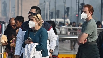 People wearing masks around Kartavya Path as a layer of toxic smog engulfs the area. (ANI)