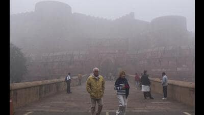 People at the Agra Fort complex as dense fog reduces visibility on a cold winter morning, in Agra, Thursday. (PTI Photo) People at the Agra Fort complex as dense fog reduces visibility on a cold winter morning, in Agra, Thursday. (PTI Photo)
