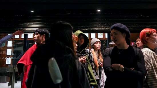 Staff from Eslite Spectrum Nanxi store near Zhongshan station wait to return to the building to collect their personal belongings while the building is cordoned off with yellow crime scene tape, following an incident in which several were injured after a person released smoke bombs and attacked bystanders, according to the government and local media, in Taipei, Taiwan, December 19, 2025.&nbsp;(REUTERS)