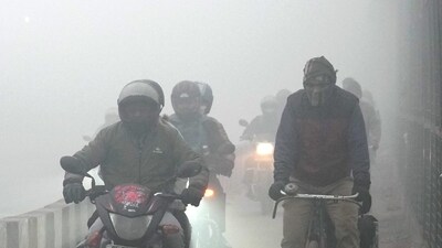Commuters brave dense fog on a winter morning, in New Delhi. (PTI) Commuters brave dense fog on a winter morning, in New Delhi. (PTI)