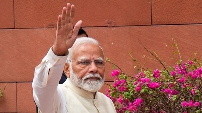Prime Minister Narendra Modi waves as he arrives at the Parliament House complex. (PTI)