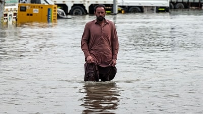 A man wades through flood waters, following heavy rains, in Dubai on December 19, 2025. (AFP) A man wades through flood waters, following heavy rains, in Dubai on December 19, 2025. (AFP)