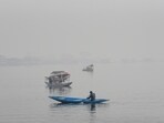 A boatmen row boats on the Dal Lake on a cold and foggy morning, in Srinagar on Saturday. (ANI)