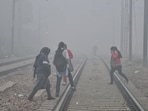 People crossing the railway track amid dense fog, in New Delhi.