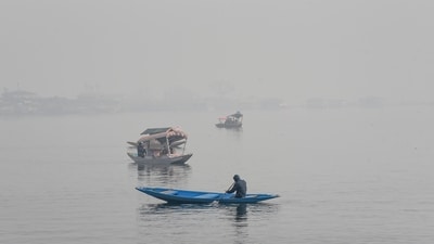 A boatmen row boats on the Dal Lake on a cold and foggy morning, in Srinagar on Saturday. (ANI) A boatmen row boats on the Dal Lake on a cold and foggy morning, in Srinagar on Saturday. (ANI)