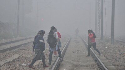 People crossing the railway track amid dense fog, in New Delhi. (ANI) People crossing the railway track amid dense fog, in New Delhi. (ANI)