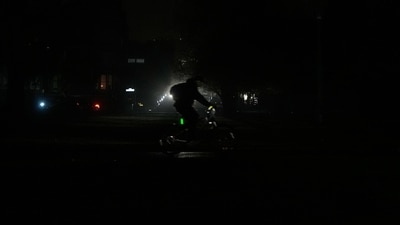 A bicyclist drives past head lights from an oncoming vehicle as power outages darken the streets, in San Francisco, Saturday, Dec. 20, 2025. (AP Photo/Jeff Chiu) (AP) A bicyclist drives past head lights from an oncoming vehicle as power outages darken the streets, in San Francisco, Saturday, Dec. 20, 2025. (AP Photo/Jeff Chiu) (AP)