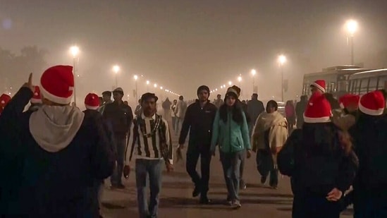 Gram it: Visitors at Kartavya Path walk amid a layer of smog as the entire sky above them appears engulfs in toxic air. Some weekend revellers add the much needed holiday cheer to the greys by flaunting red Santa caps! Delhi's AQI continues to remain 'very poor' as it stays above 300. (Photo: ANI)