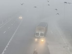 Commuters make their way through dense fog on a cold winter morning in Dausa on Monday. 