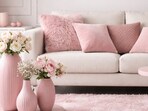A collection of pink vases, cushions, rugs, and tables brings playful charm and gentle sophistication to a stylish living area.(AI generated)