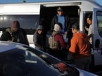 File photo of Immigration and Customs Enforcement (ICE) agents checking the identity documents of a workers at a grocery store parking lot during an immigration raid in California. 