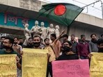Students with black cloth tied over their faces hold placards during a silent protest to condemn the lynching of Hindu garment worker Dipu Chandra Das near the Raju Memorial Sculpture at Dhaka University in Dhaka on December 21. (AFP)