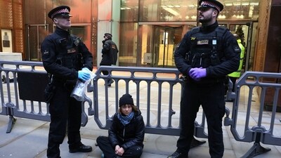A police officer takes away a sign that Swedish activist Greta Thunberg was holding during a pro-Palestinian protest that says she supports prisoners linked to Palestine Action, an organisation which the British government has proscribed as a terrorist group, in London, Britain, December 23, 2025.&nbsp; (via REUTERS)